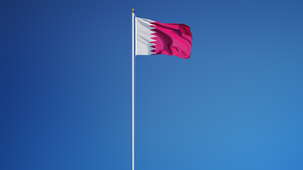 Flag of Qatar against blue sky